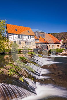 Historic water mill in Buchfart on the Ilm river near Weimar with a waterfall at the water weir