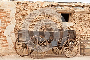 Historic western horse cart dusty mud brick wall