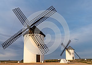 The historic white windmills of La Mancha above the town of Campo de Criptana in warm evening light