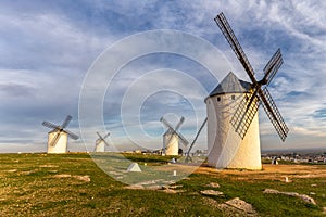 The historic white windmills of La Mancha above the town of Campo de Criptana in warm evening light