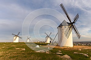 The historic white windmills of La Mancha above the town of Campo de Criptana in warm evening light