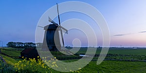 Historic windmill near Schemerhorn in the Netherlands under evening light