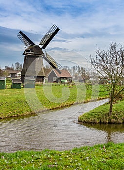 Historic windmill next to canal in Holland