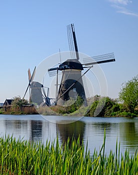 Historic windmills with grass in foreground at Kinderdijk, Holland, Netherlands, a UNESCO World Heritage Site.