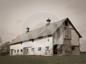 Historic wood barn with gable roof, tile sides, ventilator cupolas