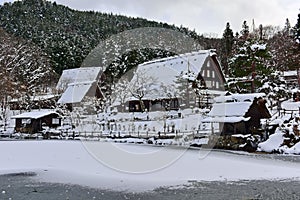 Historic wooden houses from Edo period covered in snow at Hida Folk Village in Takayama, Japan