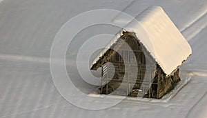 Historic wooden tool shed surrounded by fresh snow fields