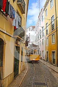 Historic yellow tram against old town streets, Lisbon, capital city of Portugal