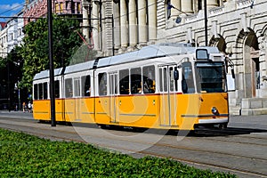 Historic yellow tram for passengers driving through the streets and part of the public transport system in in the old center in a