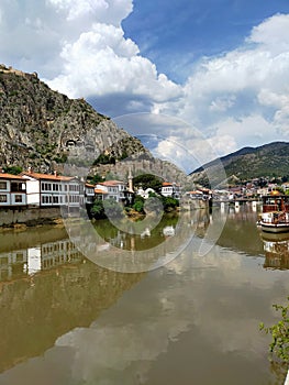 Historical Amasya houses on the banks of the KÃÂ±zÃÂ±lÃÂ±rmak River and Kralkaya  King rock tombs cemeteries on the back. photo