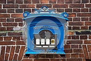 Historical blue post box on a brick wall in Lauenburg in northern Germany on the river Elbe, still in use and now a tourist