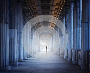 A historical building and a man walking into the light