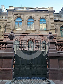 Historical building with ornaments and  fence with wrought iron gates