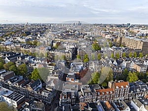 Historical Center of Amsterdam, Netherlands. Aerial Drone Shot of Traditional Dutch houses on narrow street and channel.