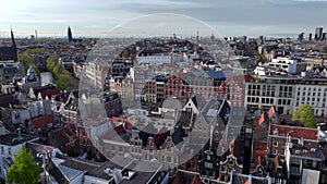 Historical Center of Amsterdam, Netherlands. Aerial Drone Shot of Traditional Dutch houses on narrow street and channel.