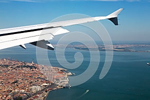 The historical center of Lisbon under the plane wing. Roofs of houses and old quarters