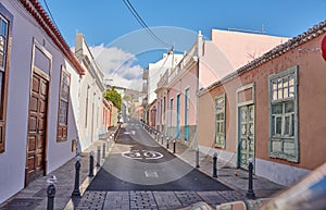 Historical city street view of residential houses in small and narrow alley or road in tropical Santa Cruz, La Palma