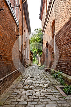 Historical cobblestone alley with red brick houses in the German medieval town Hitzacker