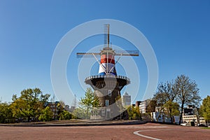 Historical Dutch windmill Molen de Valk with Dutch flag in Leiden, The Netherlands