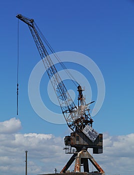 Historical industrial crane opposite a blue sky