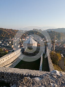 Historical landmark, the walls of the old fortress in Travnik with a mosque and tower above the city, and foggy hills in the