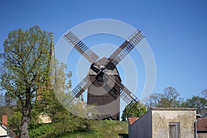 Historical wooden windmill against blue sky in Werder, Brandenburg, Germany photo
