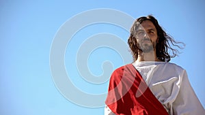 Historical personification of Jesus Christ looking after people against blue sky