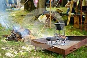 Historical reenactment activists preparing food over an open fire during annual Medieval Festival, held in Trakai Peninsular