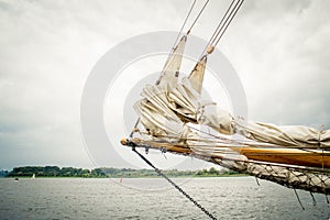 Historical sailship jib boom with wrapped sails
