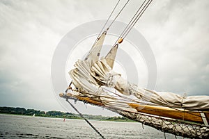 Historical sailship jib boom with wrapped sails