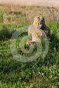 Historical Scythian monuments called kurgan stelae standing in nature against blue sky with clouds at golden house