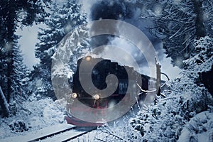 Historical steam locomotive struggles in the dark, through snow and storm to the mountain `Brocken`