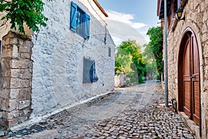 Historical stone houses and a cobblestone street in Alacati, Turkey