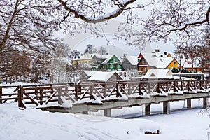 Historical Trakai town with colorful timber houses and bridge covered with snow in winter, Lithuania