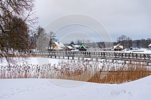 Historical Trakai village with timber houses and bridge covered with snow, Lithuania. Winter landscape