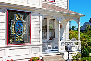 Historical white American house porch with stain glass window.