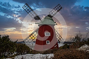 historical windmill made of red wood in a winter landscape.Stenungsund in Sweden photo