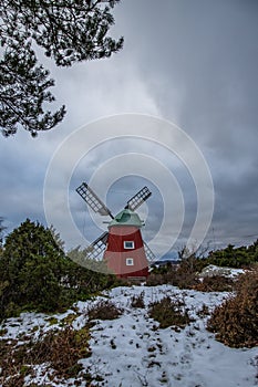 historical windmill made of red wood in a winter landscape.Stenungsund in Sweden photo