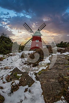 historical windmill made of red wood in a winter landscape.Stenungsund in Sweden photo