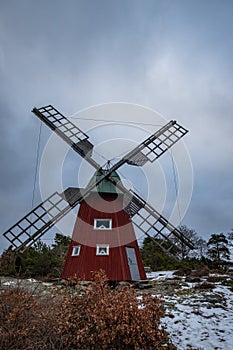 historical windmill made of red wood in a winter landscape.Stenungsund in Sweden photo