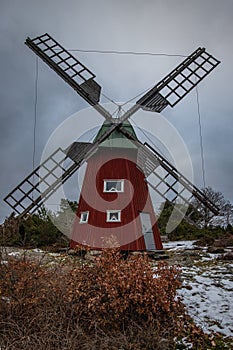 historical windmill made of red wood in a winter landscape.Stenungsund in Sweden photo