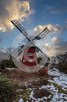 historical windmill made of red wood in a winter landscape.Stenungsund in Sweden photo