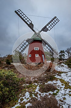 historical windmill made of red wood in a winter landscape.Stenungsund in Sweden photo