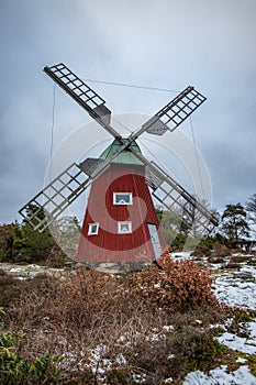 historical windmill made of red wood in a winter landscape.Stenungsund in Sweden photo