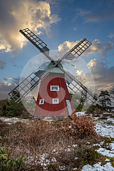 historical windmill made of red wood in a winter landscape.Stenungsund in Sweden photo