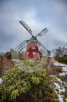 historical windmill made of red wood in a winter landscape.Stenungsund in Sweden photo