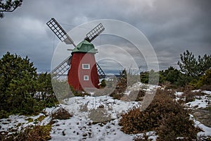 historical windmill made of red wood in a winter landscape.Stenungsund in Sweden photo