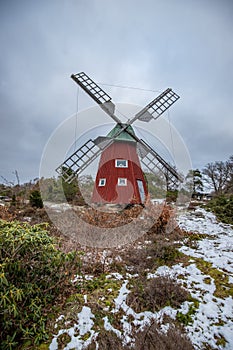 historical windmill made of red wood in a winter landscape.Stenungsund in Sweden photo