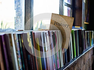 History on book cover on bookshelf, education concept