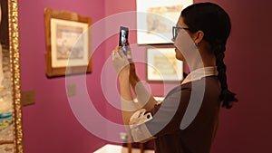 History and culture. Portrait of young pretty Caucasian woman take photo with smartphone in art gallery. Visiting